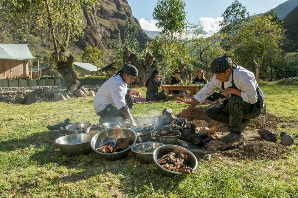 Personal cocinando pachamanca a la tierra en los jardines de las Qolqas eco resort Ollantaytambo